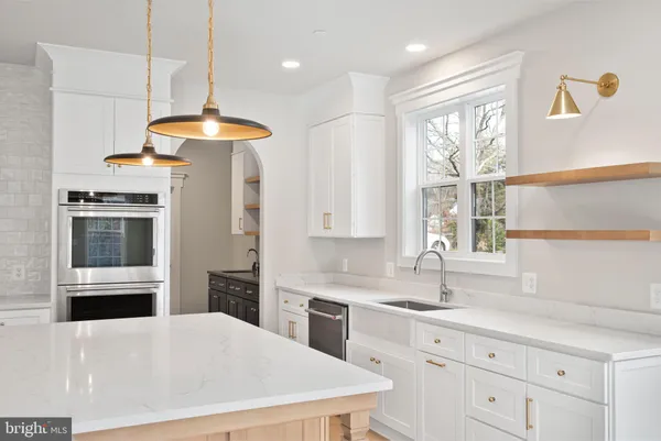 a kitchen with stainless steel appliances a stove a sink a refrigerator and windows