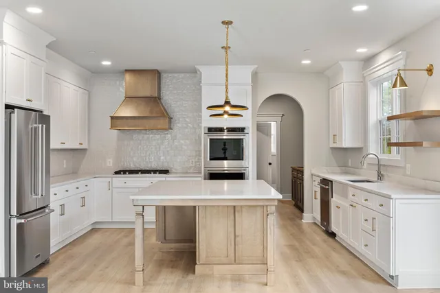 a kitchen with granite countertop a sink a stove and a refrigerator