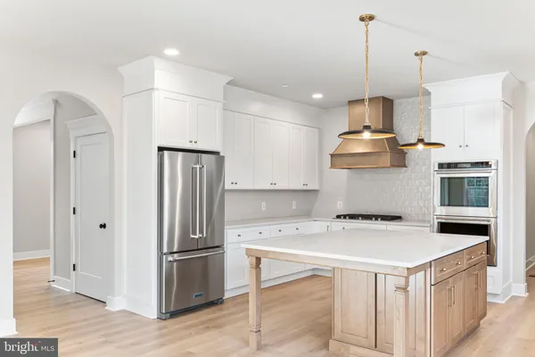 a kitchen with a refrigerator a sink and wooden floor