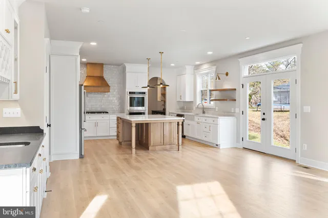 a kitchen with stainless steel appliances kitchen island granite countertop a refrigerator and cabinets