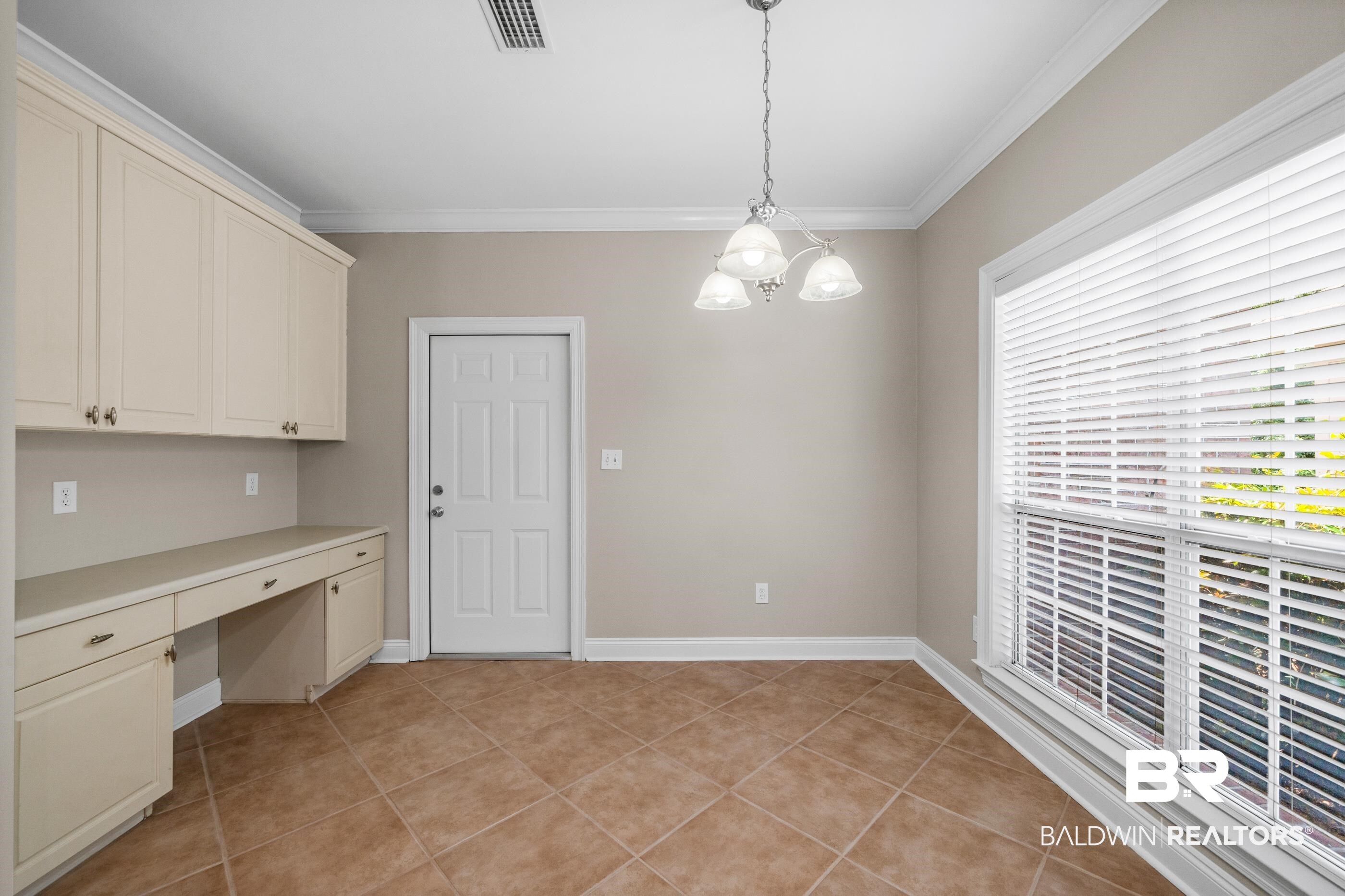 303 Savannah Circle Foley, AL 36535 - Photo 13 of 34 Neutral wall paint, tile flooring, built-in cabinetry with desk space, prominent window with blinds, and a suspended ceiling light fixture