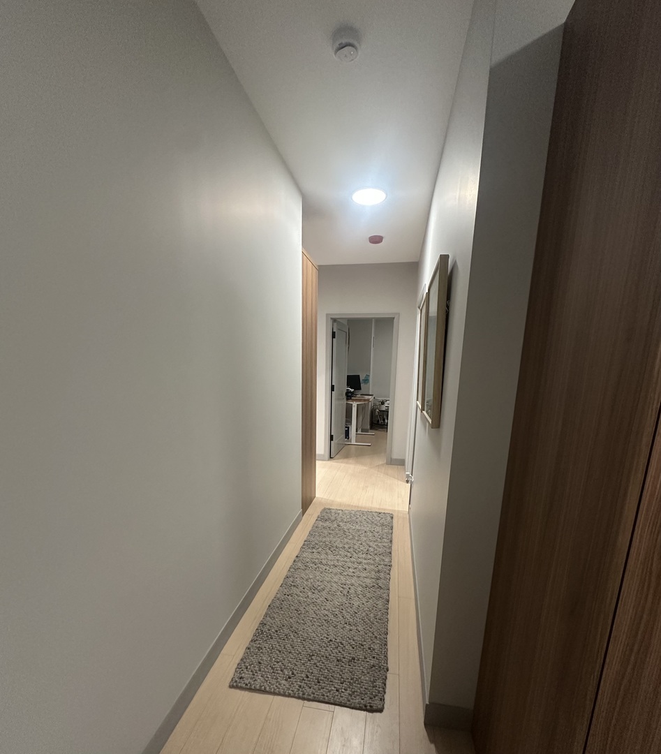 920 North Wells Street, Unit 612 Chicago, IL 60610 - Photo 13 of 14 a view of hallway with wooden floor