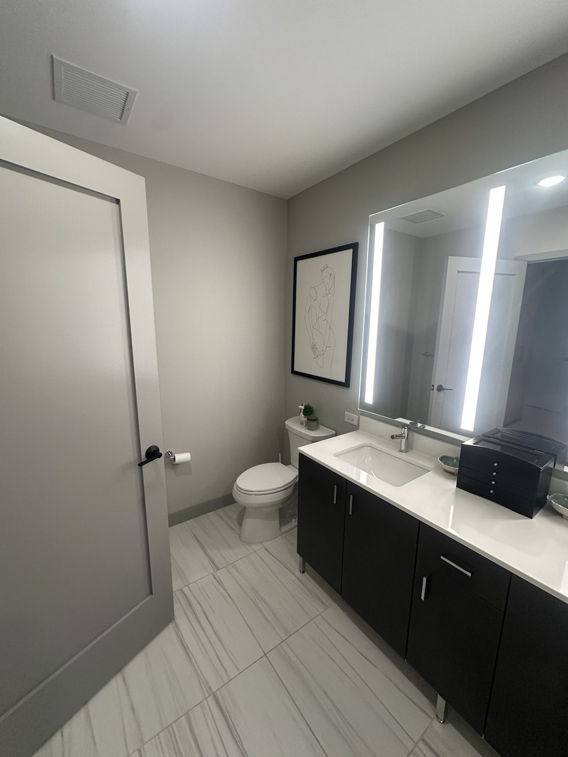 920 North Wells Street, Unit 612 Chicago, IL 60610 - Photo 7 of 14 a spacious bathroom with a double vanity sink toilet and mirror