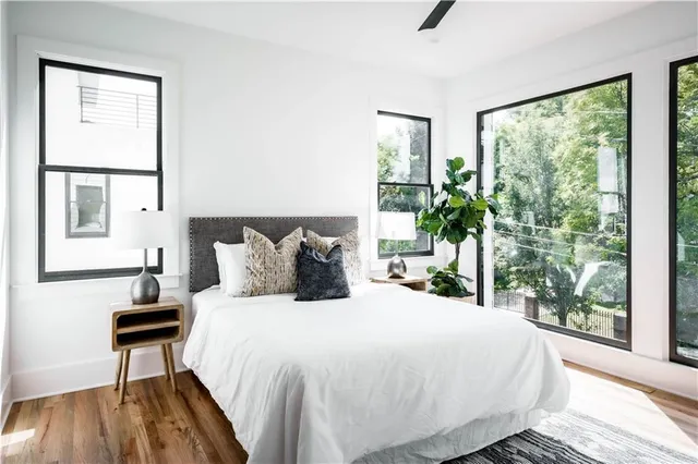 a bedroom with a bed and large windows