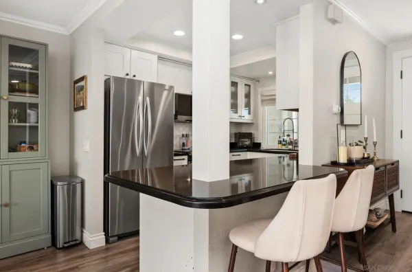 a kitchen with refrigerator and chairs