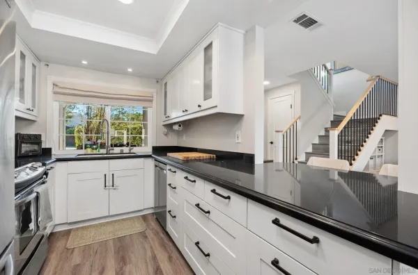 a kitchen with granite countertop a sink appliances cabinets and counter space
