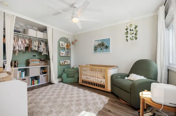 a living room with furniture and baby crib