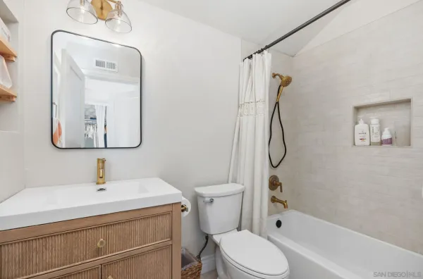 a bathroom with a toilet sink shower and mirror