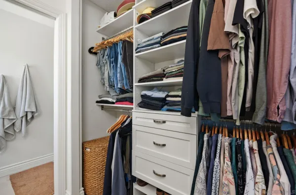 a view of walk in closet with clothes and shoes