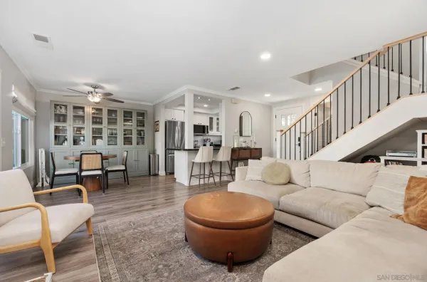 a living room with furniture and a dining table with wooden floor