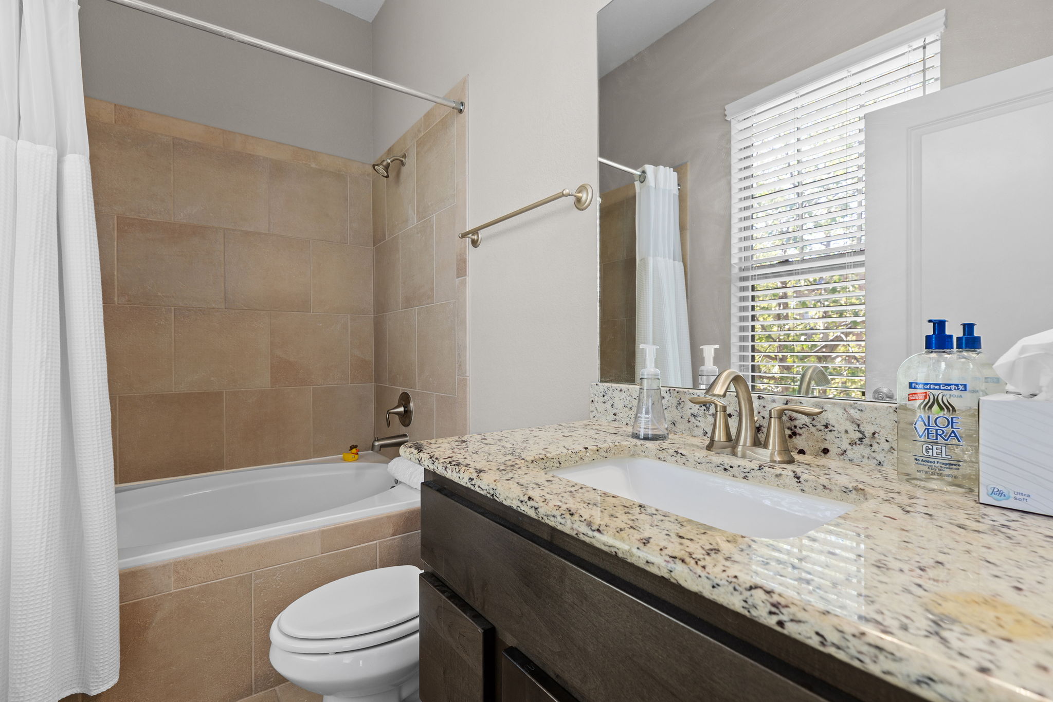 1125 Highknoll Lane Georgetown, TX 78628 - Photo 28 of 40 a bathroom with a granite countertop sink a toilet and bathtub