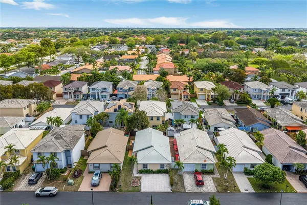 an aerial view of residential houses with outdoor space and street view