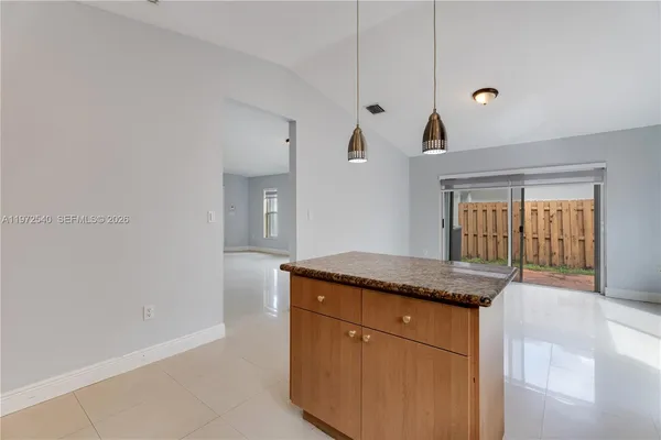 a kitchen with granite countertop cabinets stainless steel appliances a sink and a window