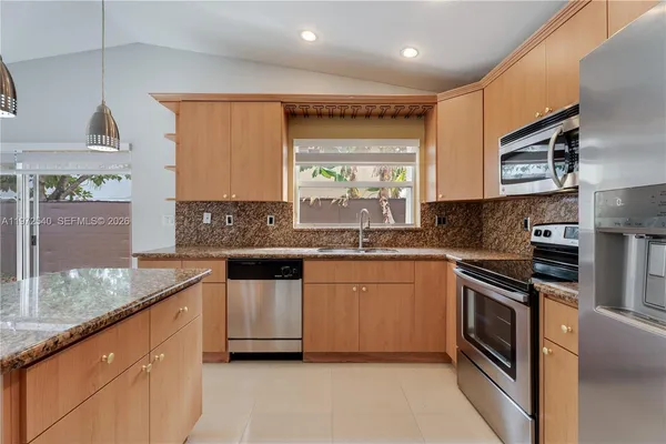 a kitchen with stainless steel appliances granite countertop a sink and stove top oven