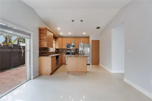 a kitchen with white cabinets and refrigerator