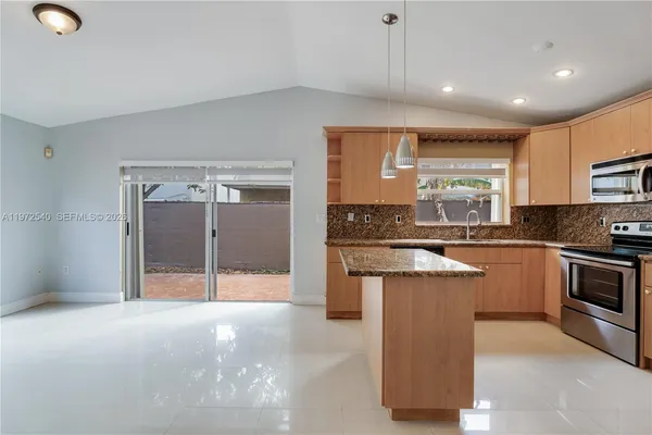 a kitchen with stainless steel appliances granite countertop a stove a sink and a refrigerator