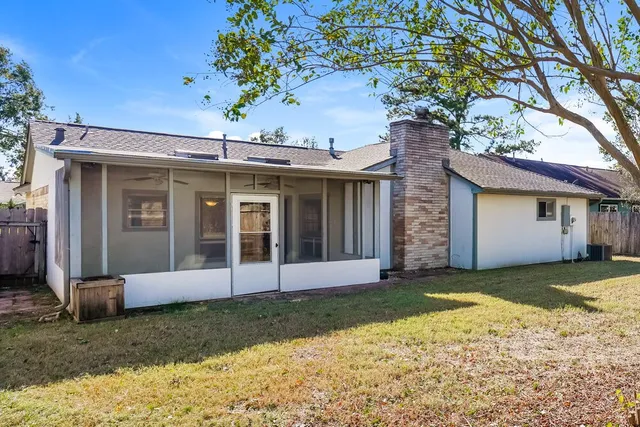 a view of a house with a yard and large tree
