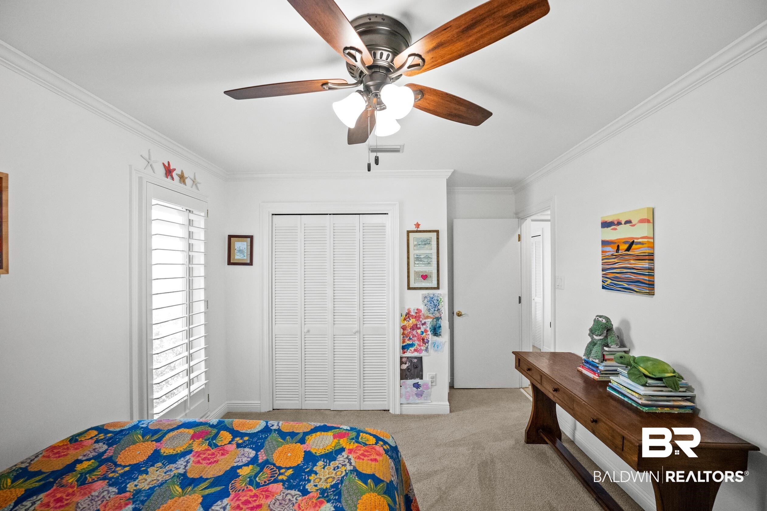 31304 River Road Orange Beach, AL 36561 - Photo 38 of 78 Carpeted bedroom featuring a closet, a ceiling fan, ornamental molding, visible vents, and baseboards