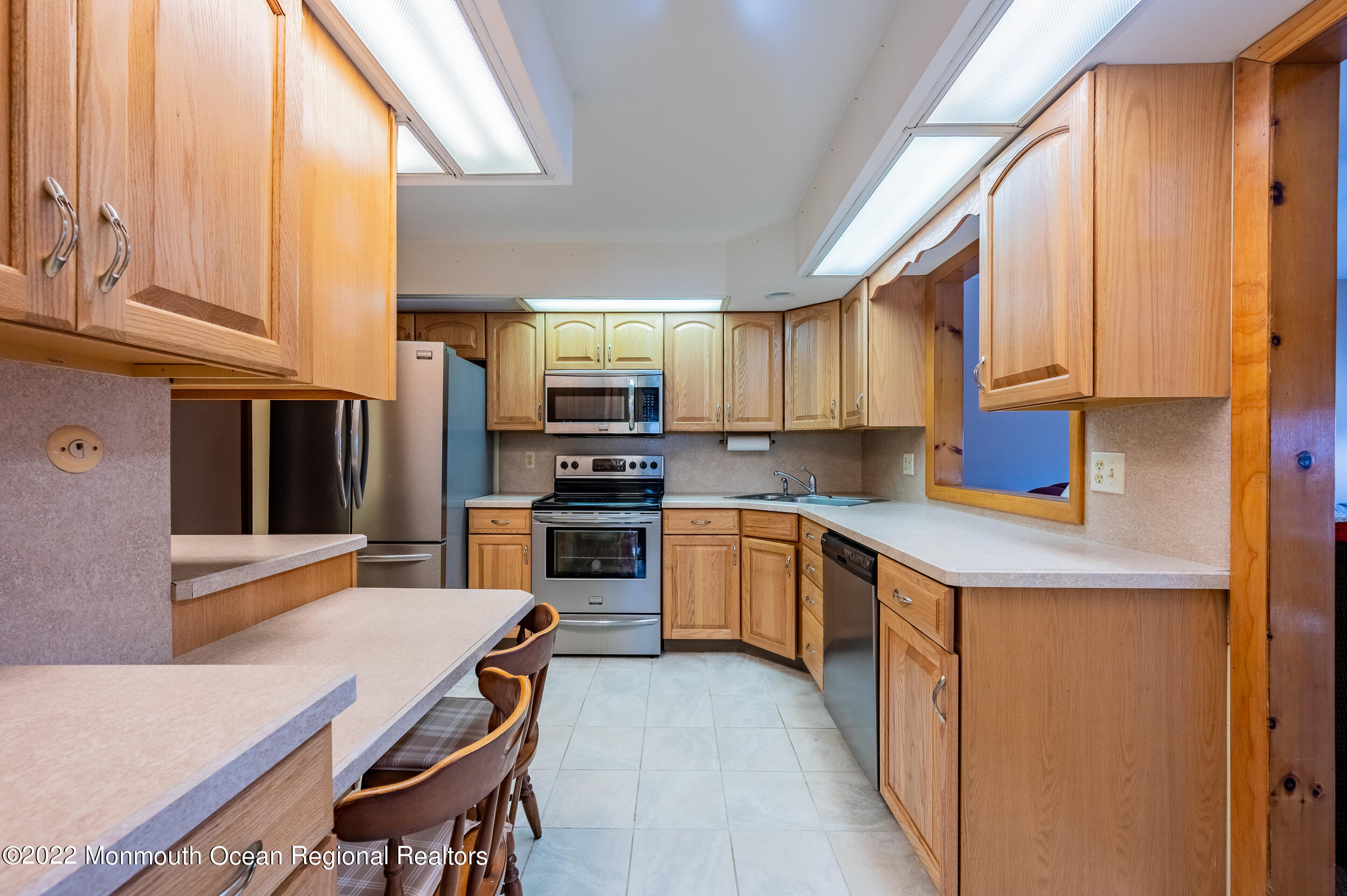23 Neptune Road Toms River, NJ 08753 - Photo 12 of 36 a kitchen with stainless steel appliances a stove a sink a microwave a refrigerator and cabinets