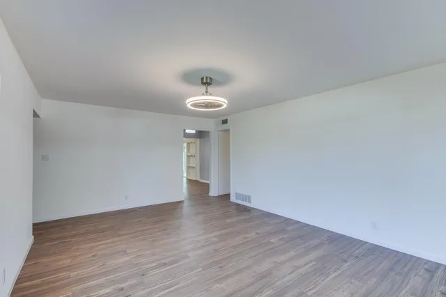 a view of an empty room with wooden floor