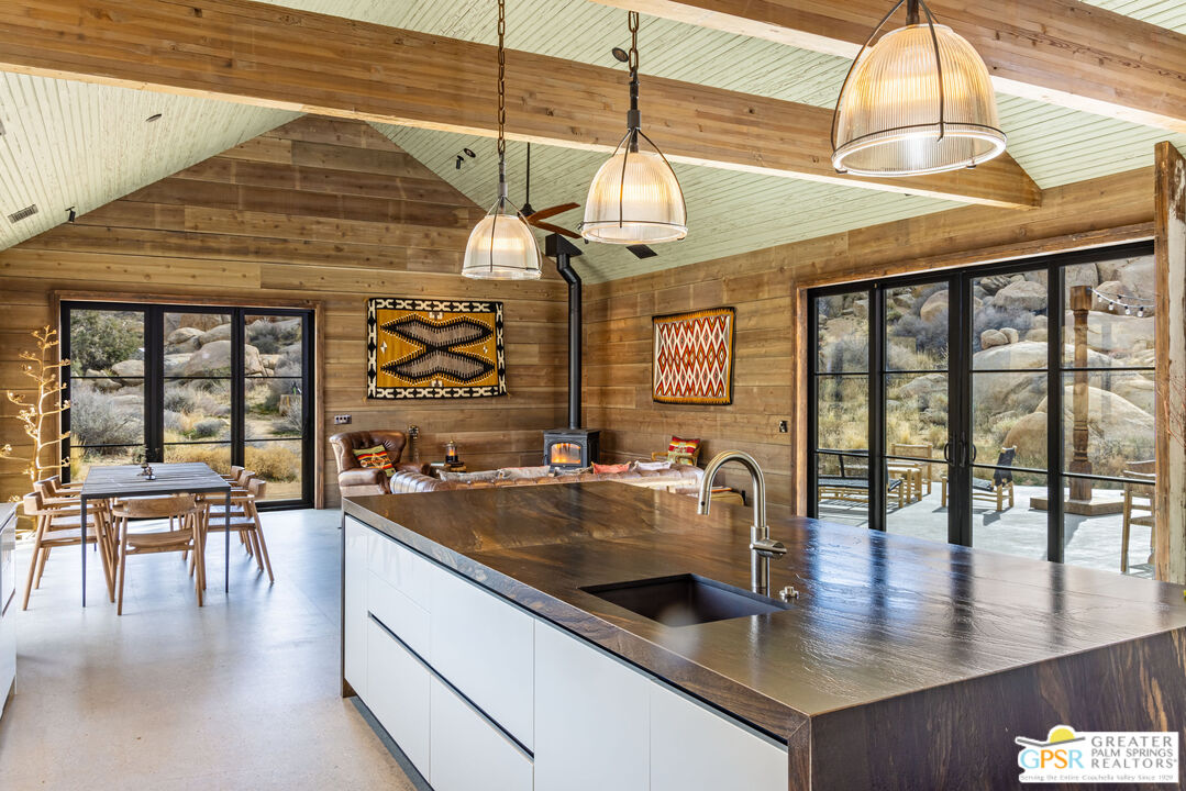 1653 Roadrunner Rut Pioneertown, CA 92268 - Photo 18 of 60 a kitchen with a table chairs and flat screen tv