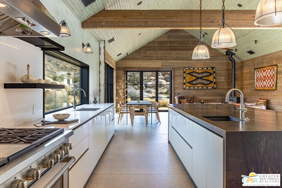 1653 Roadrunner Rut Pioneertown, CA 92268 - Photo 19 of 60 a kitchen with stainless steel appliances granite countertop a sink a stove and a wooden floors