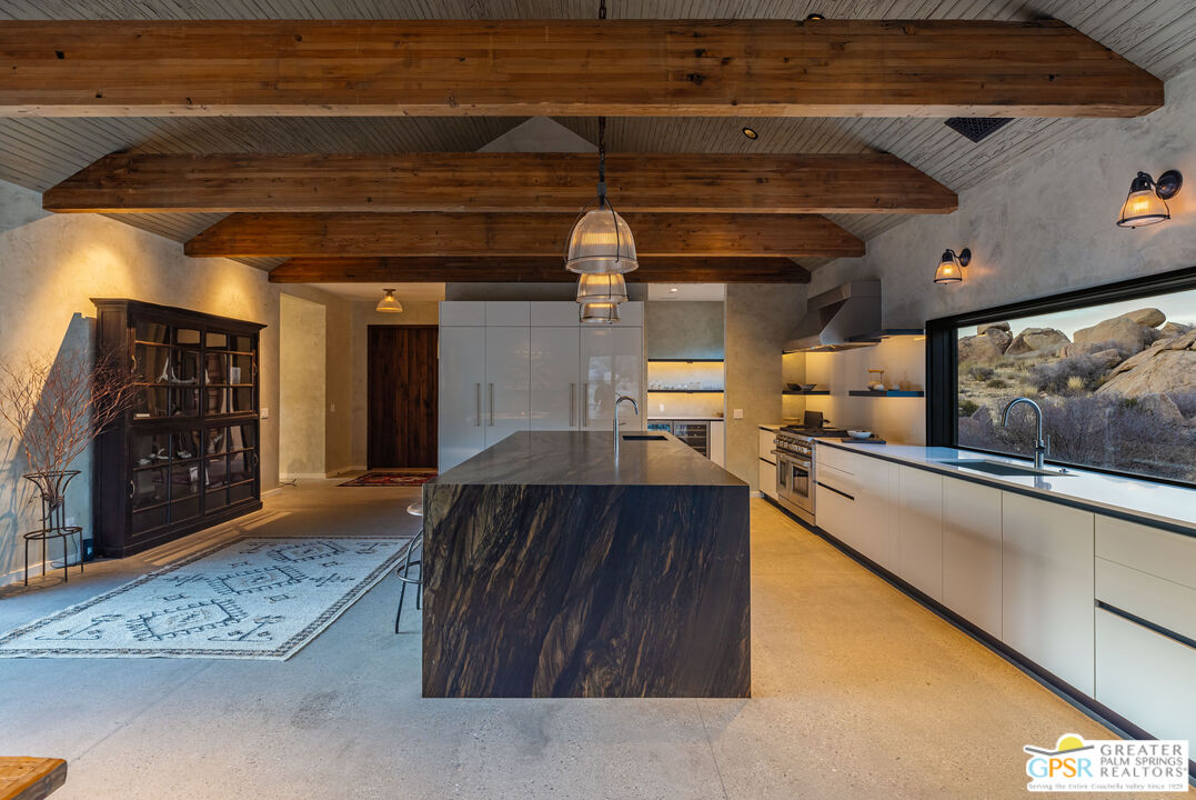 1653 Roadrunner Rut Pioneertown, CA 92268 - Photo 25 of 60 a kitchen with stainless steel appliances granite countertop a sink a stove and a wooden floors