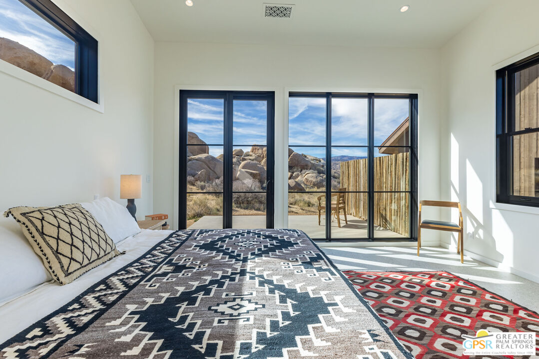 1653 Roadrunner Rut Pioneertown, CA 92268 - Photo 26 of 60 a bedroom with a large bed and a large window