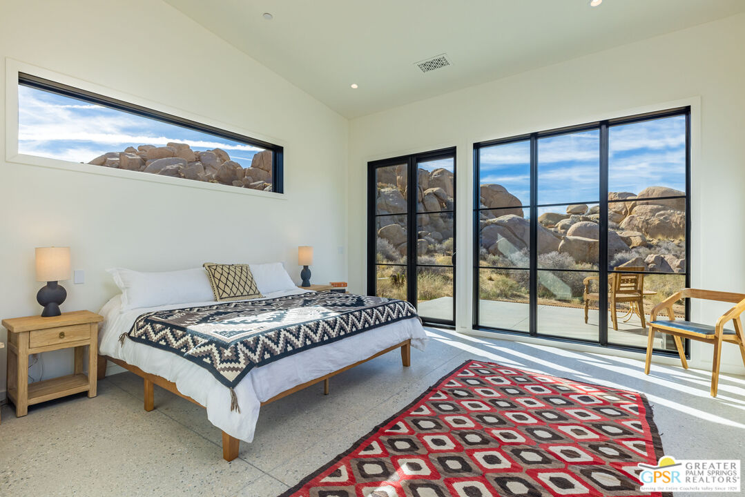 1653 Roadrunner Rut Pioneertown, CA 92268 - Photo 27 of 60 a bedroom with a bed and a lamp next to a window