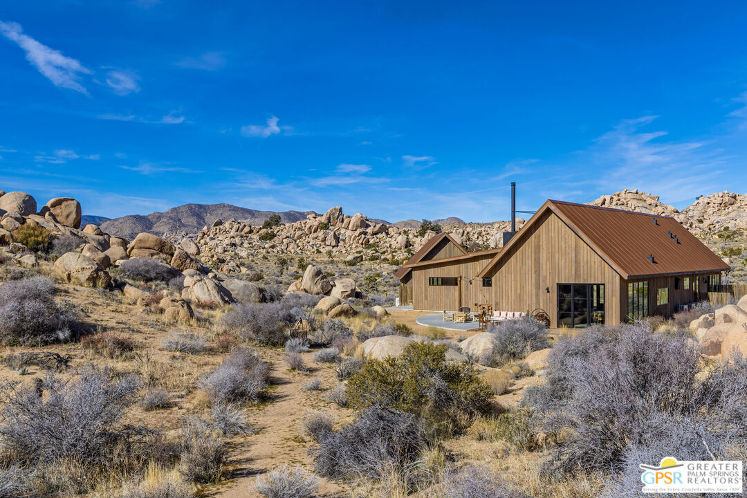 1653 Roadrunner Rut Pioneertown, CA 92268 - Photo 7 of 60 a view of a large house with a big yard and large trees
