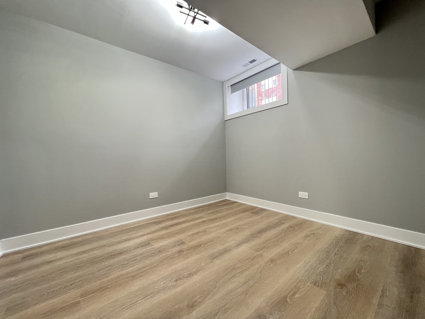 911 South Miller Street, Unit G Chicago, IL 60607 - Photo 11 of 11 a view of an empty room with wooden floor and windows