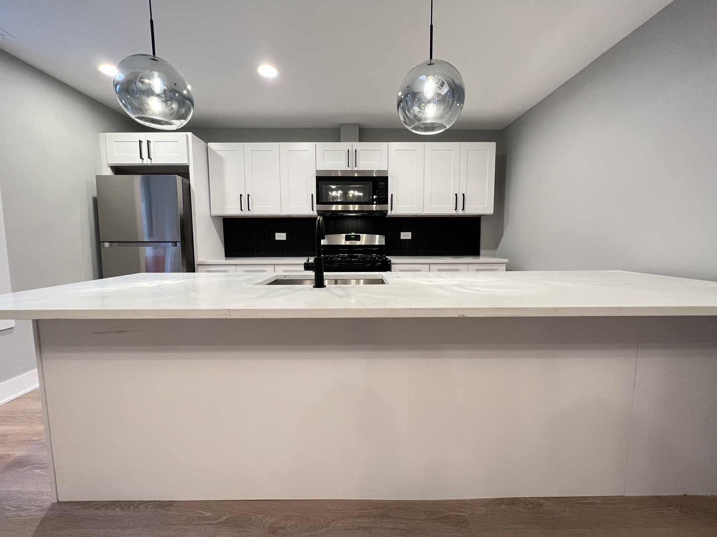 911 South Miller Street, Unit G Chicago, IL 60607 - Photo 4 of 11 a view of a kitchen with a sink and stainless steel appliances