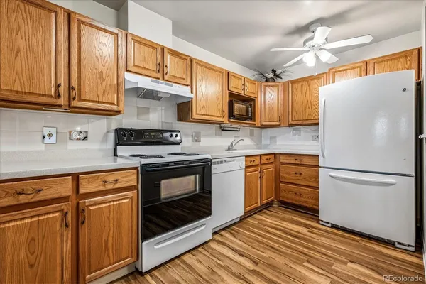 a kitchen with stainless steel appliances granite countertop a refrigerator sink and stove