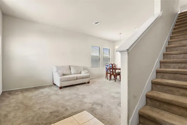 a living room with furniture and stairs