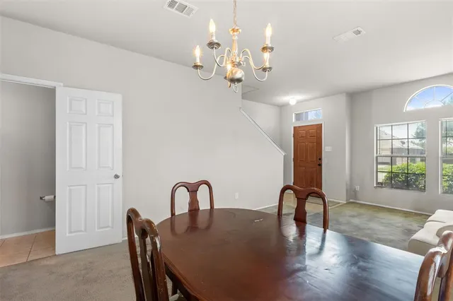 a view of a dining room with furniture a chandelier and wooden floor