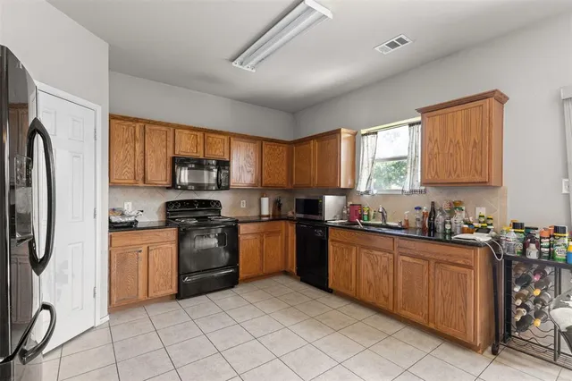 a kitchen with stainless steel appliances granite countertop a stove a sink dishwasher a refrigerator and a microwave oven