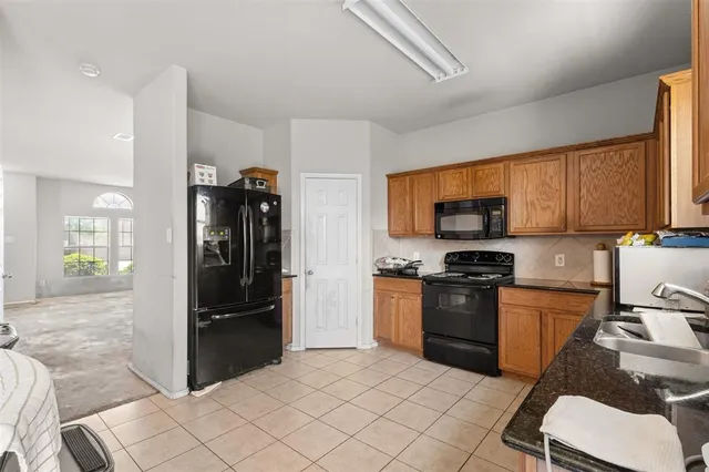 a kitchen with stainless steel appliances granite countertop a refrigerator stove top oven and sink