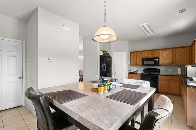 a view of a dining room and a kitchen with a table chairs