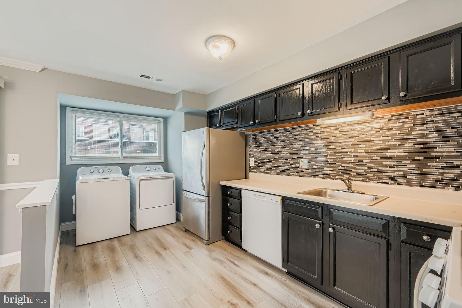 2610 Hallam Court, Unit 2610 Windsor Mill, MD 21244 - Photo 9 of 17 a kitchen with a refrigerator and white cabinets
