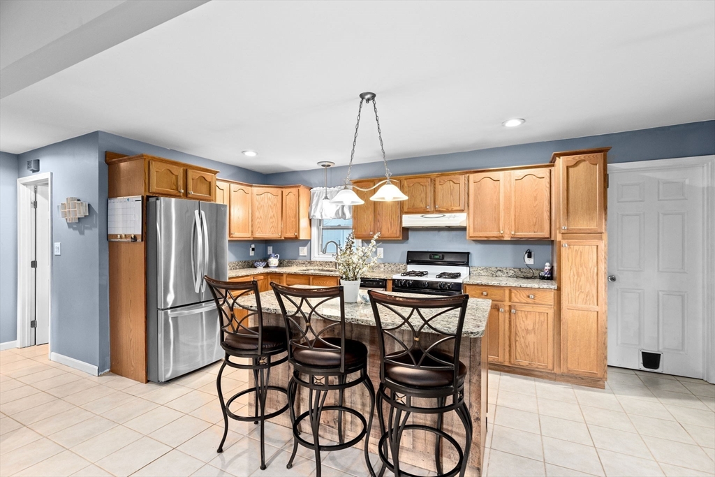 973 Point Road Marion, MA 02738 - Photo 2 of 33 a kitchen with stainless steel appliances granite countertop a refrigerator oven a stove a sink with a dining table and chairs