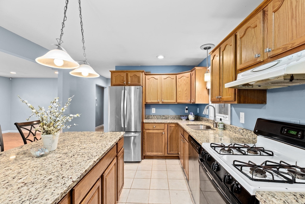 973 Point Road Marion, MA 02738 - Photo 3 of 33 a kitchen with stainless steel appliances granite countertop a stove a sink dishwasher and a refrigerator with wooden cabinets