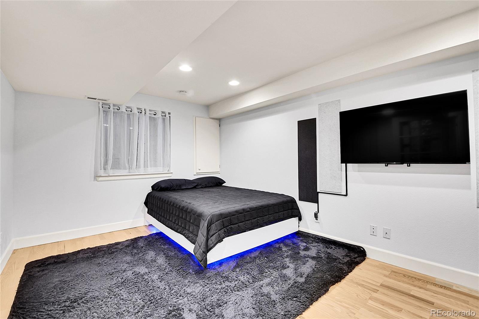 566 Josephine Street Denver, CO 80206 - Photo 27 of 45 a bedroom with a bed and a flat screen tv