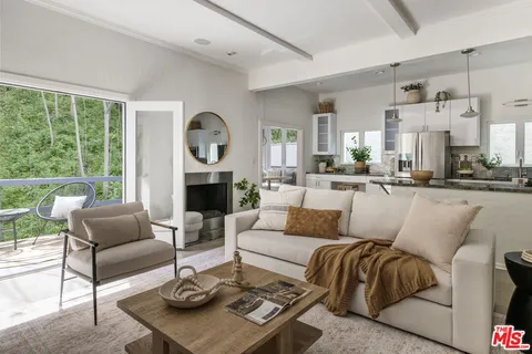 a living room with furniture a large window and a fireplace