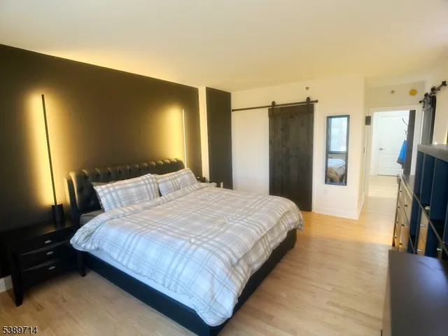 a bedroom with a bed and a flat tv screen on a dresser