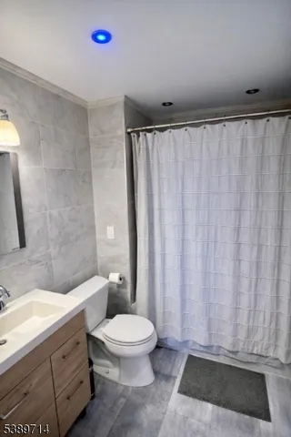 a bathroom with a granite countertop bathtub shower sink and toilet