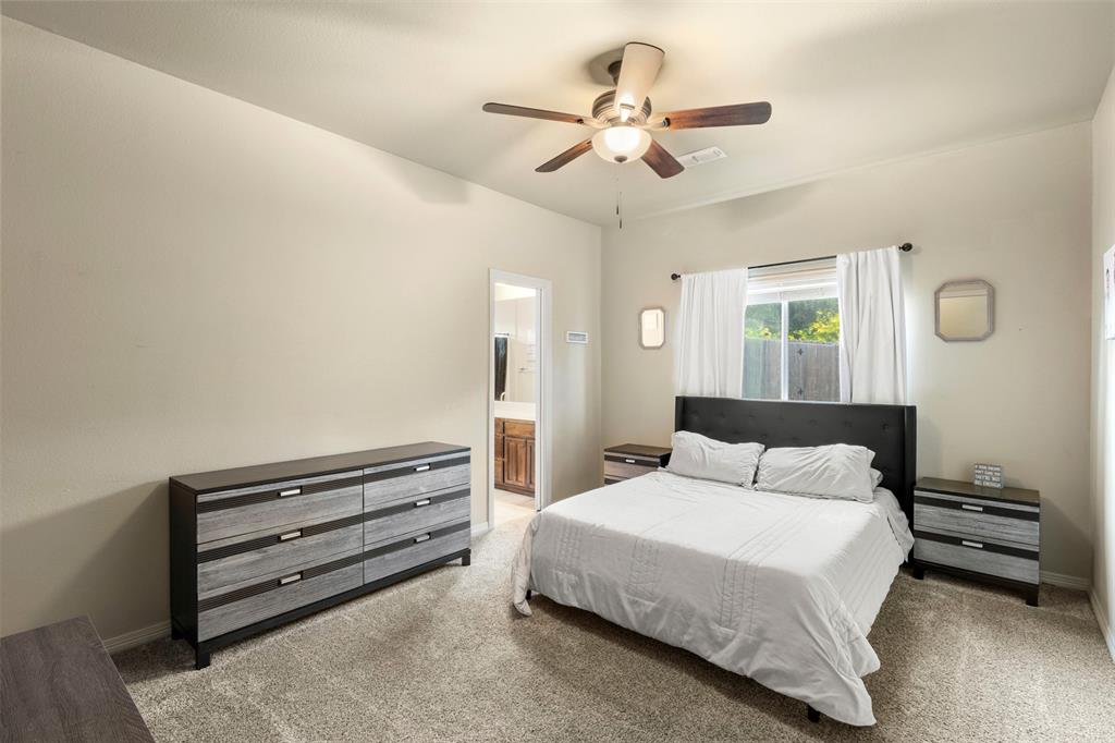 105 Country Ridge Court Red Oak, TX 75154 - Photo 26 of 40 a bedroom with a bed and a chandelier