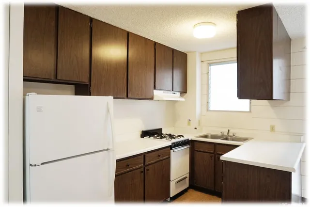 a kitchen with a sink a stove and a refrigerator