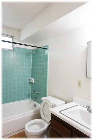 a bathroom with a sink and bathtub with toilet