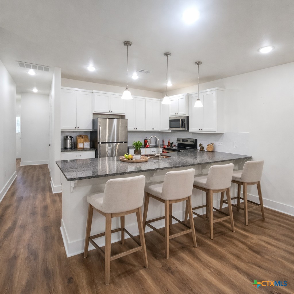 1952 Royal Loop Belton, TX 76513 - Photo 4 of 15 a kitchen with a dining table chairs wooden floor cabinets and appliances