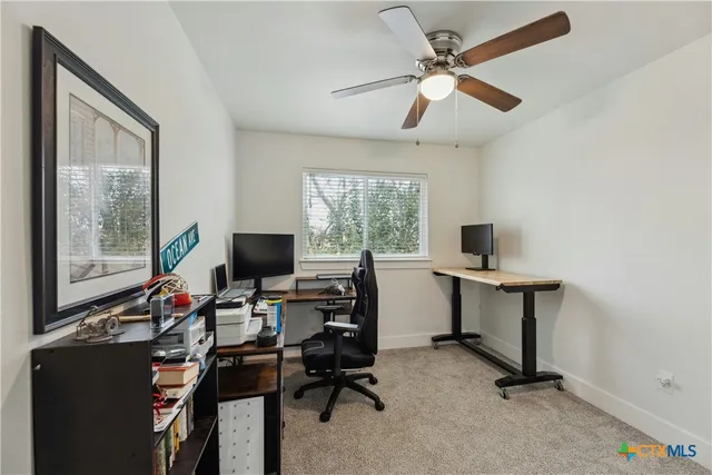 a view of a workspace with furniture and a window